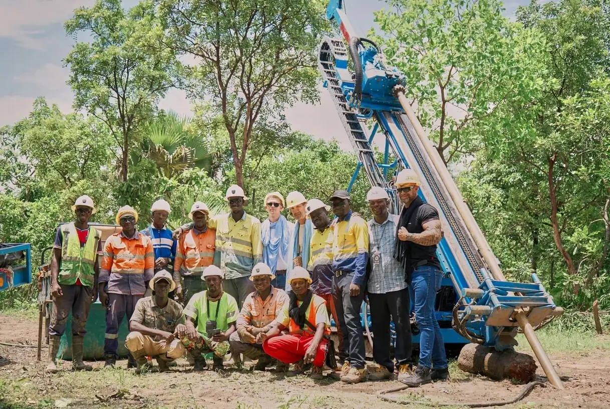 The Komassala Sud crew standing with the drilling rig at the exploration site in southern Mali.
